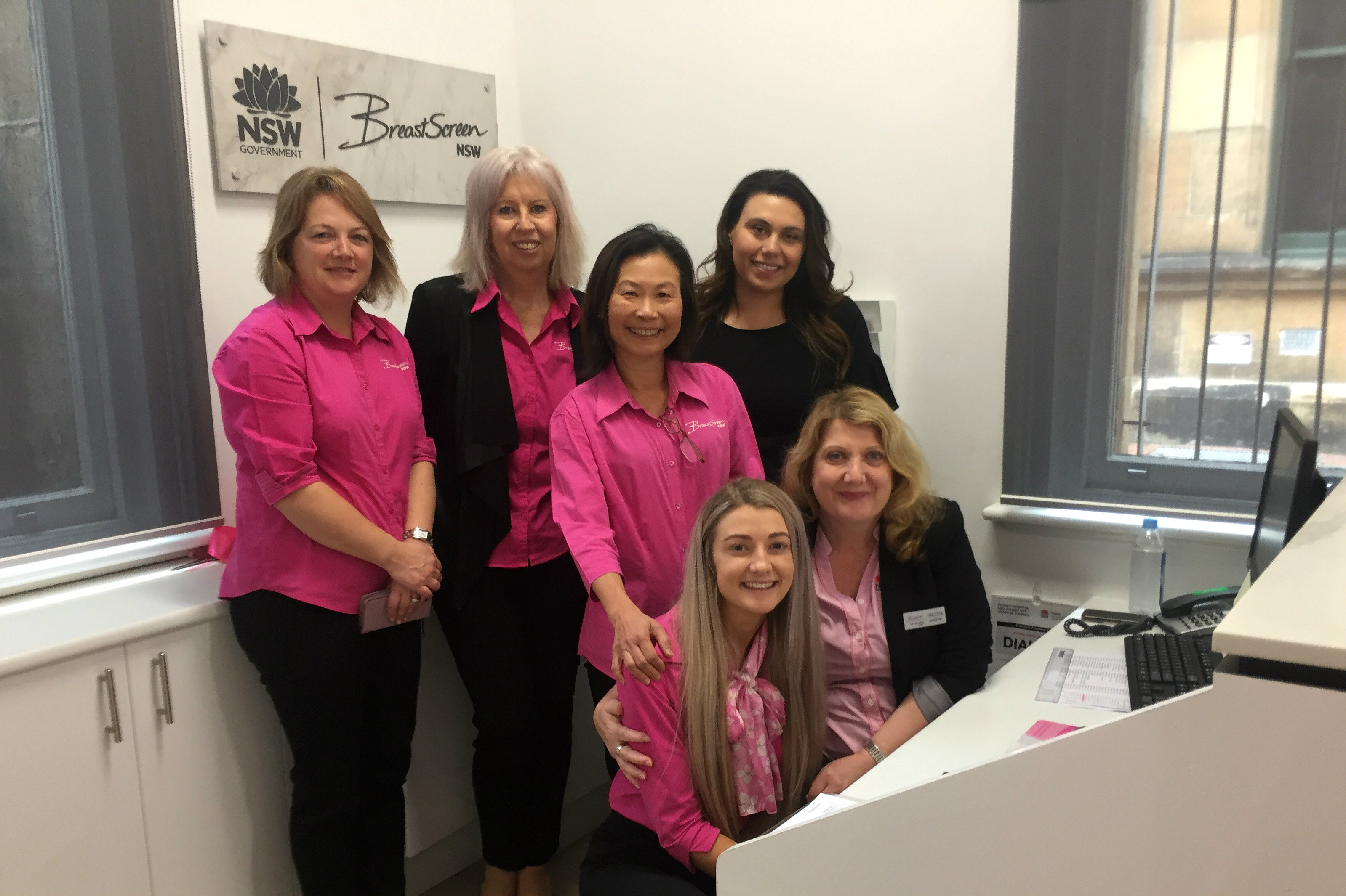Staff in pink t-shirts at reception desk