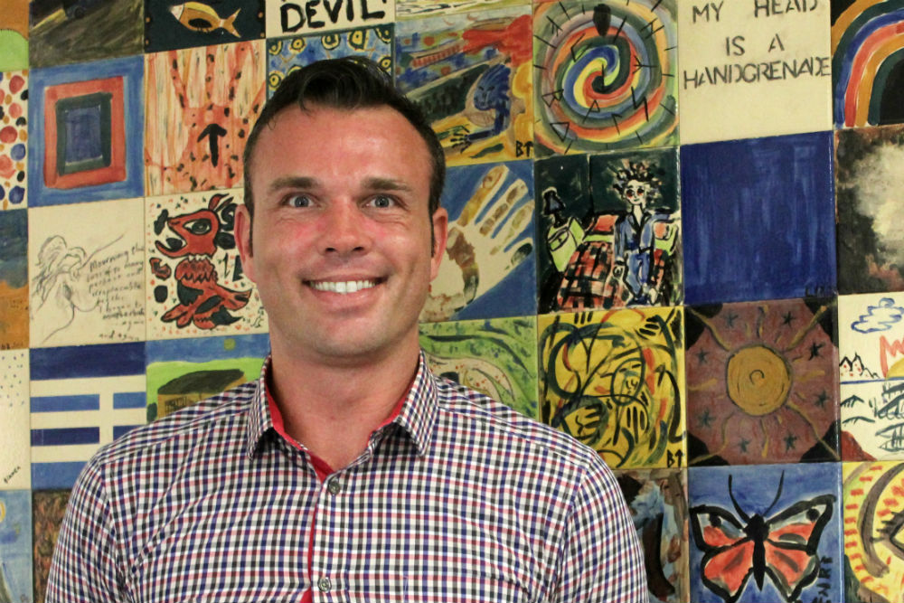 Man in front of colourful mural