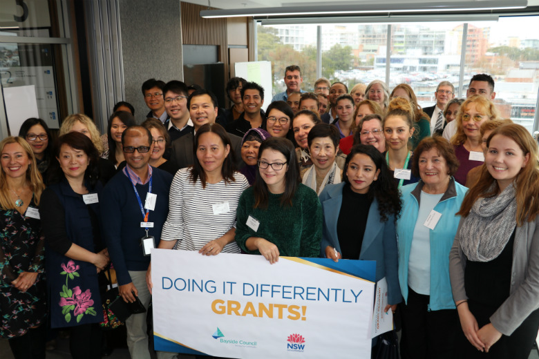 Large group of people with Doing It Differently sign