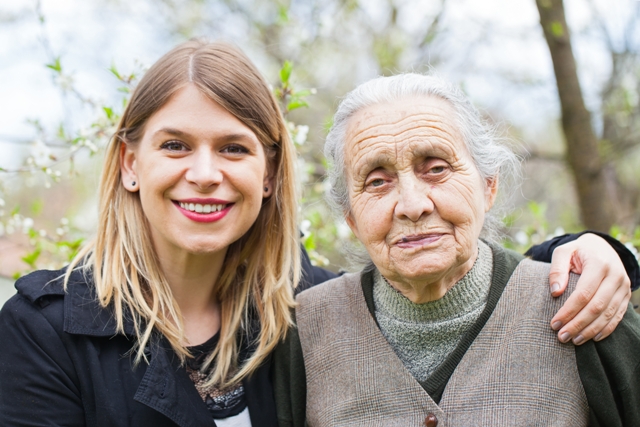 A young woman with her arm around the shoulders of an older woman