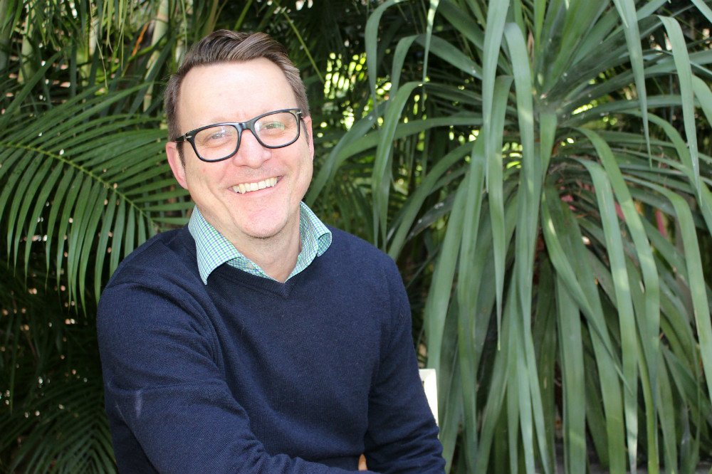 Man sitting in front of greenery