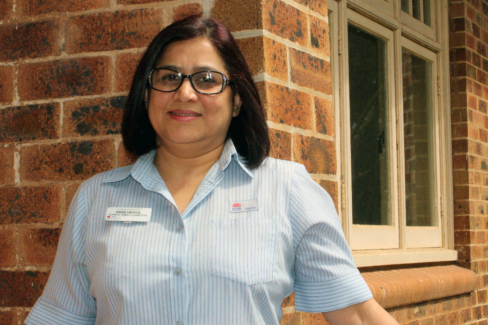 Woman with glasses standing in front of building