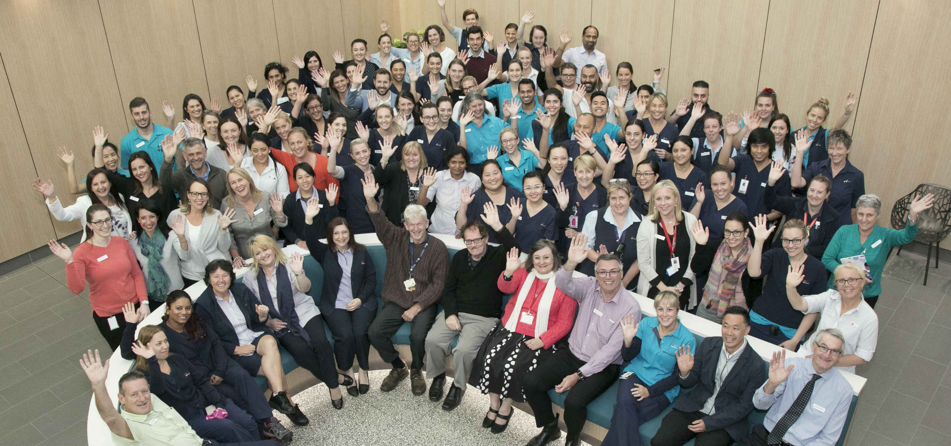 Large group of staff waving