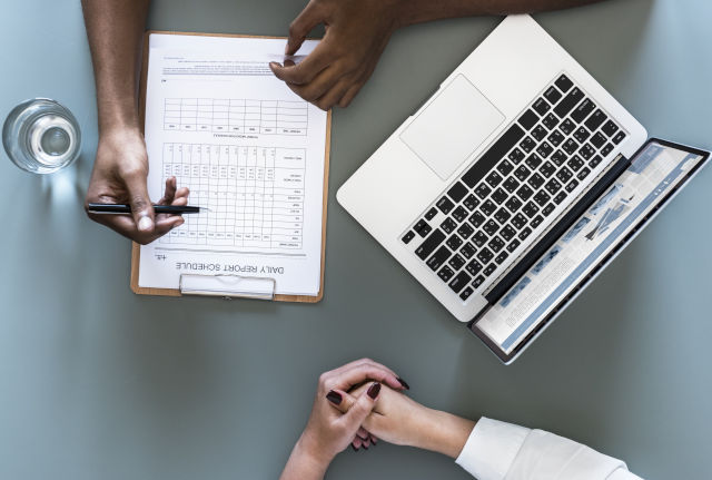 Hands, laptop and report on desk. Unit provides general advice and information on adult and childhood immunisation to healthcare providers, excluding travel vaccination. 