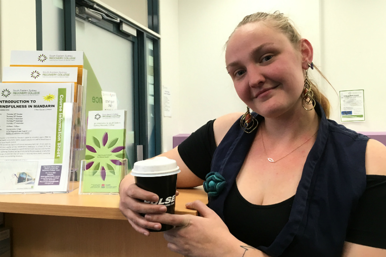 Woman holding coffee cup in office