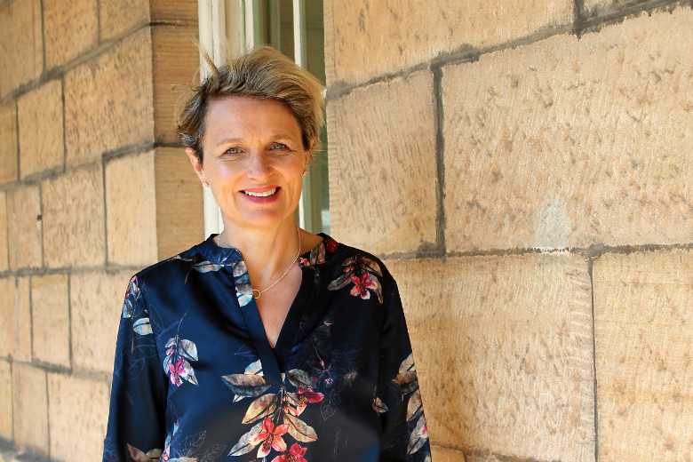 Woman standing in front of sandstone wall