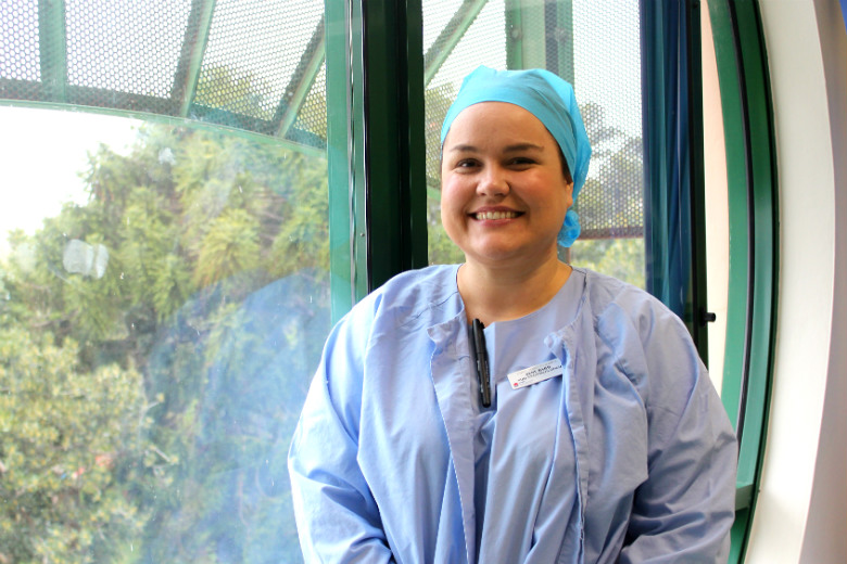 Nurse in surgical uniform standing in front of window