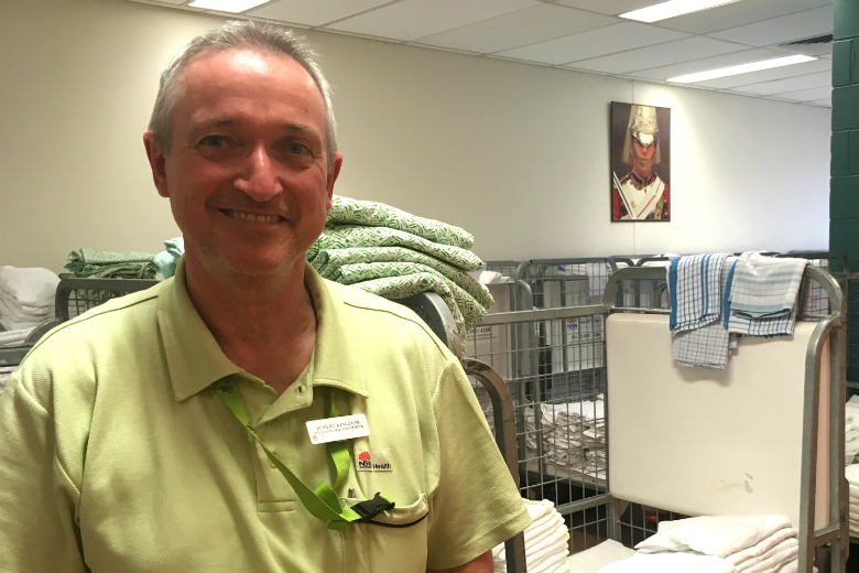 Gentleman in front of stacked linen