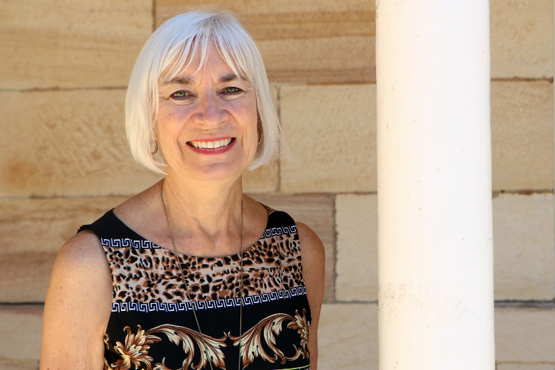 Smiling woman in front of sandstone wall