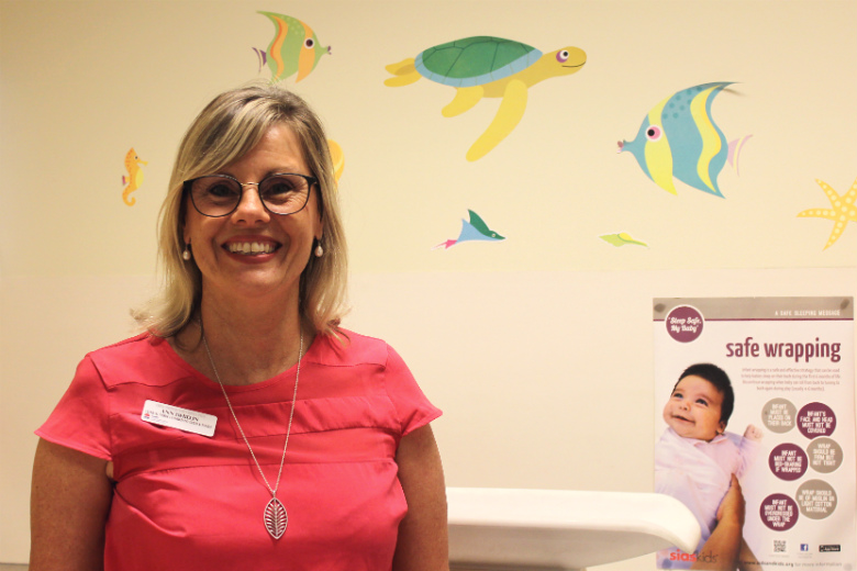 Lady in front of colourful wall in consulting room