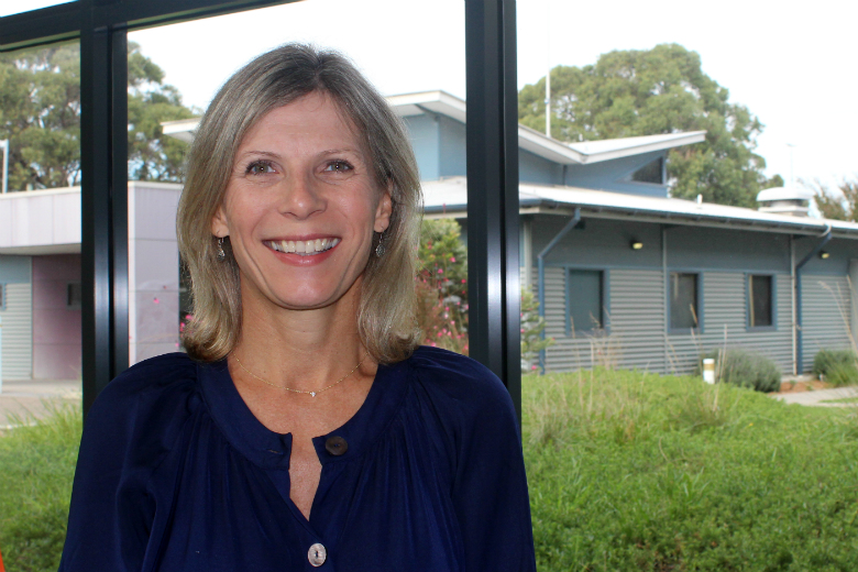 Smiling woman in front of windows