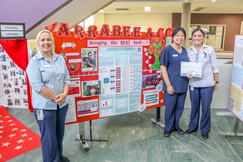 Staff standing in front of their posters 