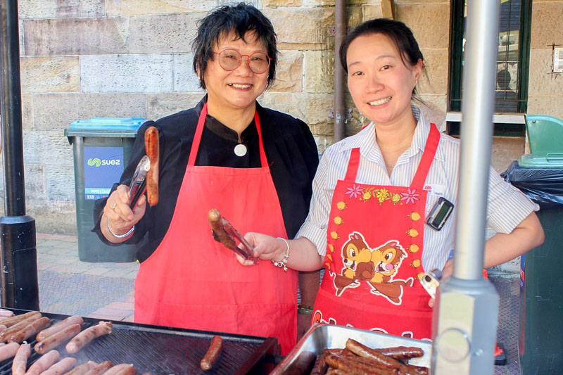 Staff cooking sausages on the BBQ 