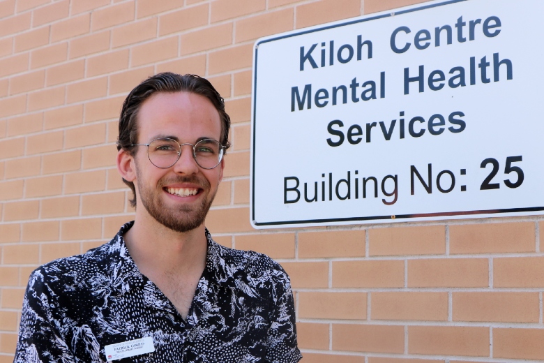 Gentleman standing in front of Mental Health sign at hospital