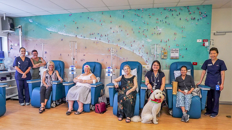 Patients and staff in front of mural 