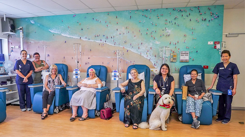 Patients and staff in front of mural