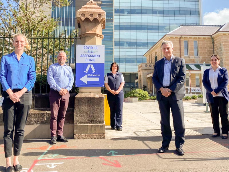 Infectious Disease team members standing next to COVID-19 Clinic sign 