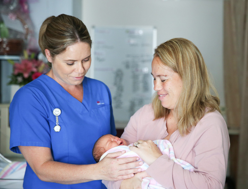 Midwife, mother and newborn baby 
