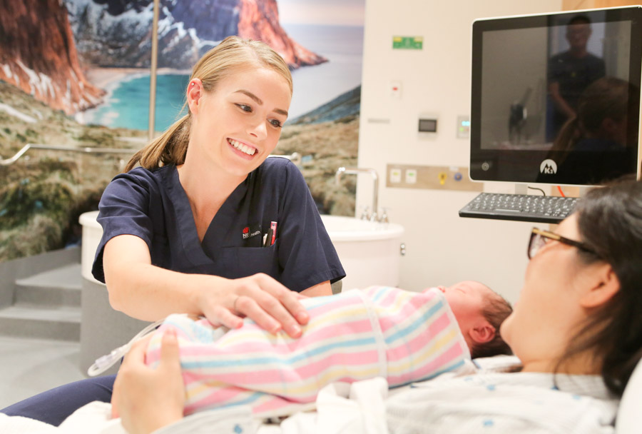 New mother and baby with midwife