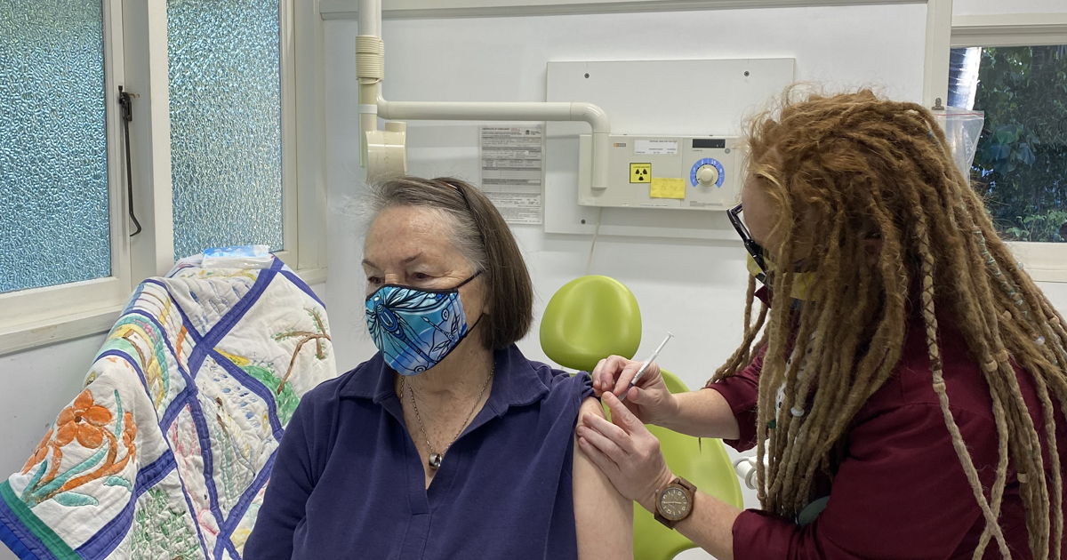 Dr San Clarke vaccinating Dorothea Wilson