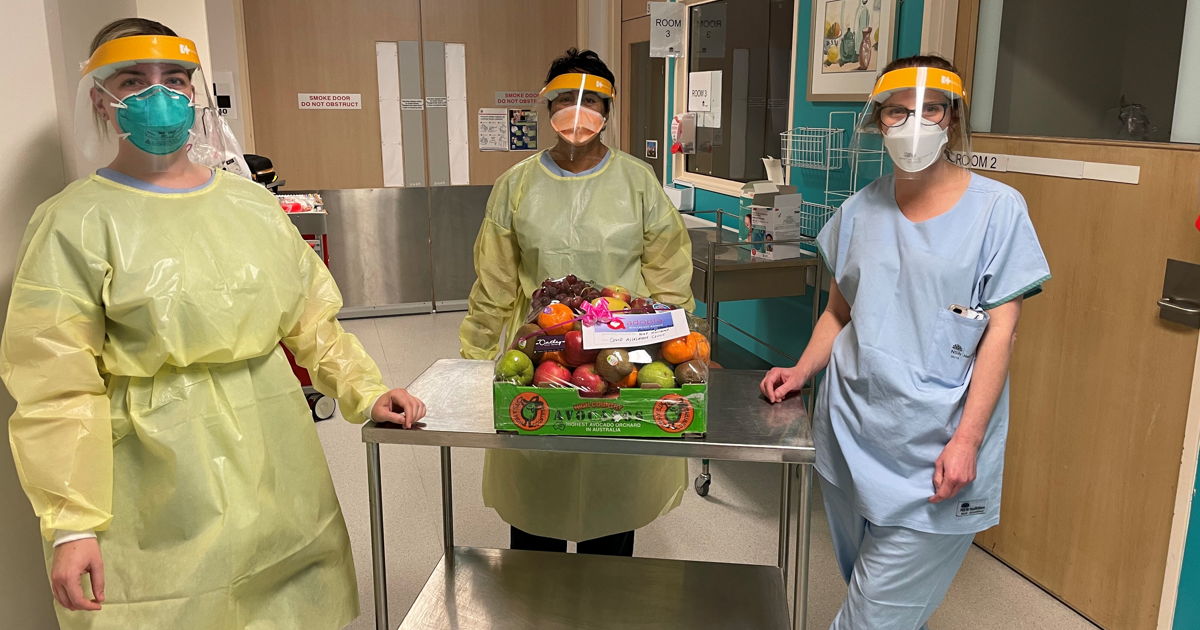 Staff in PPE with fruit box