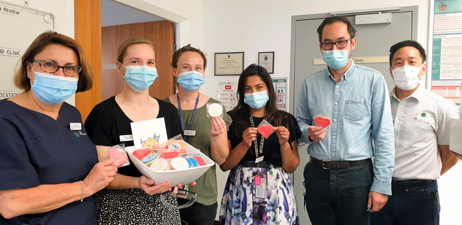 Staff holding Foundation Day biscuits