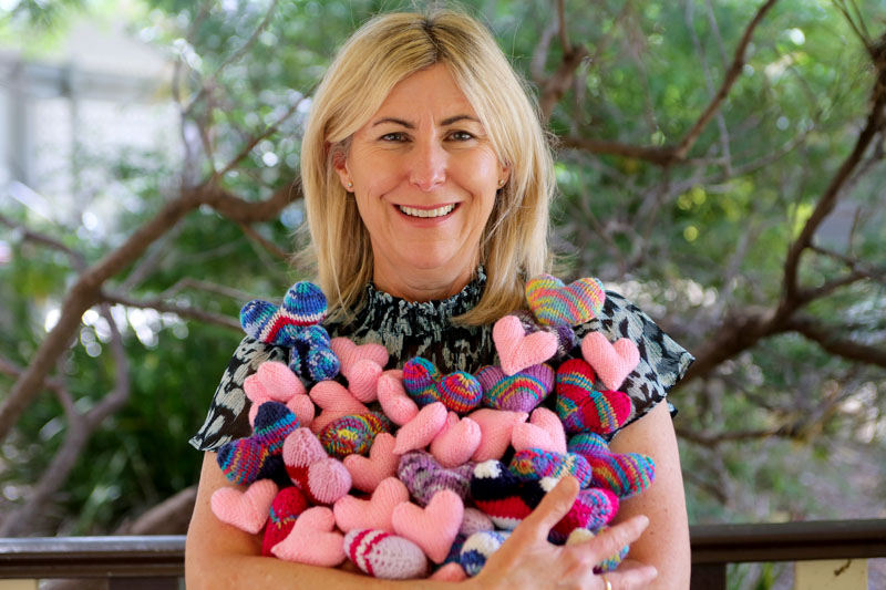 Staff member holding a big bunch of hearts in her arms 