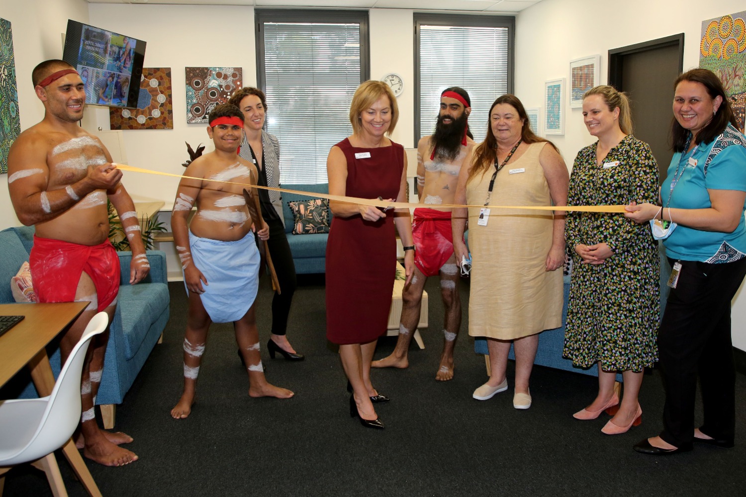 Staff cutting a ribbon to officially open the lounge 