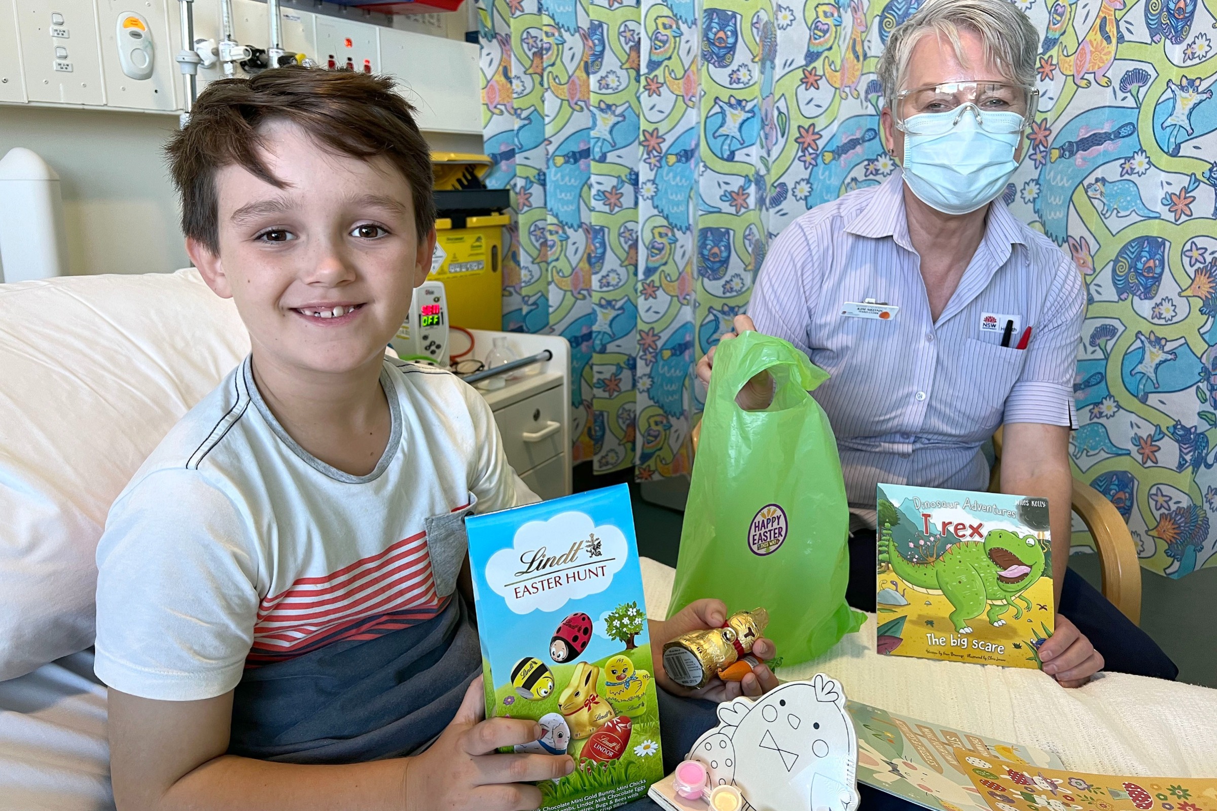 A young patient and staff member holding Easter eggs