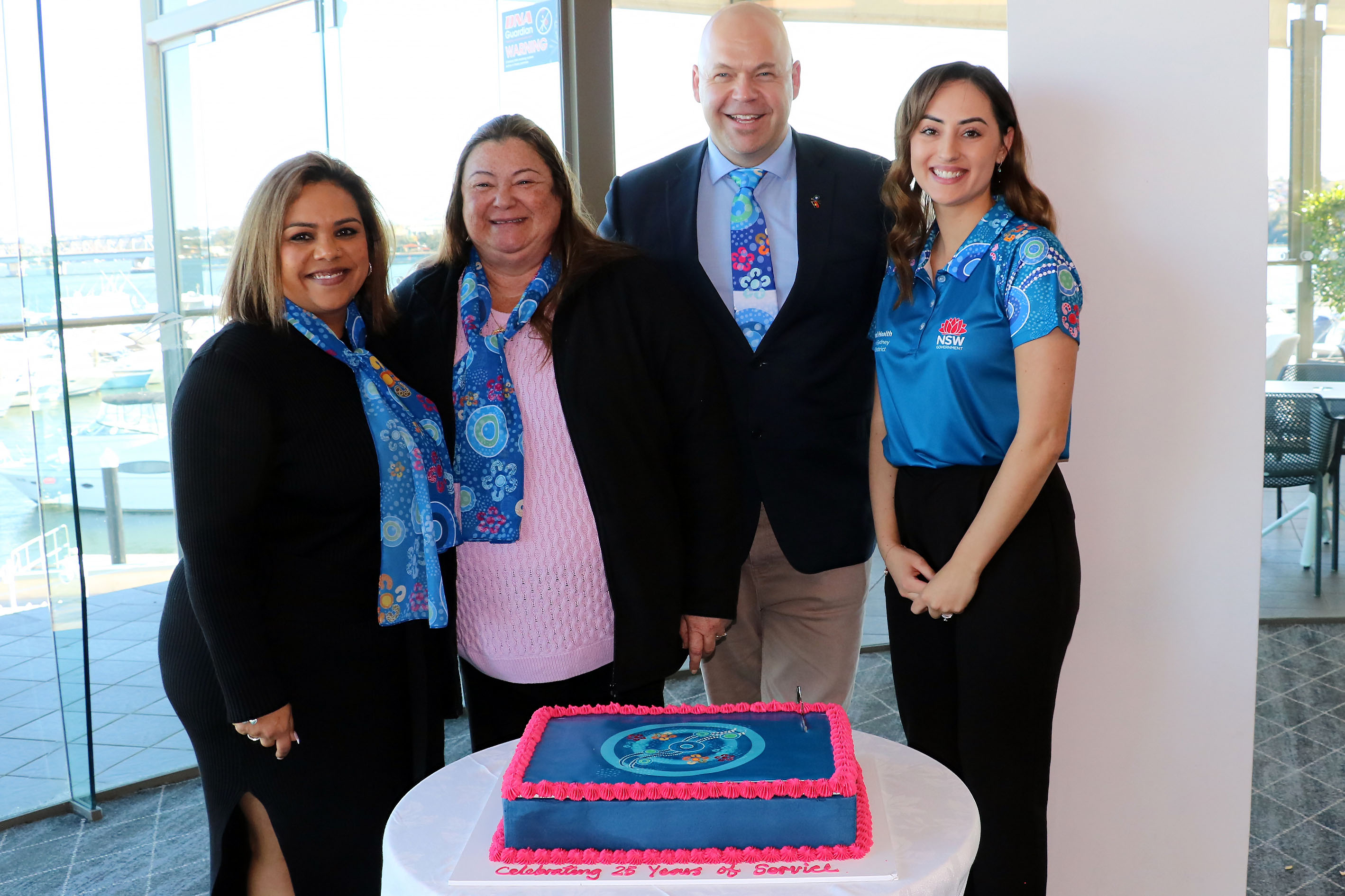 Group of four members of Aboriginal Health Unit with celebratory cake