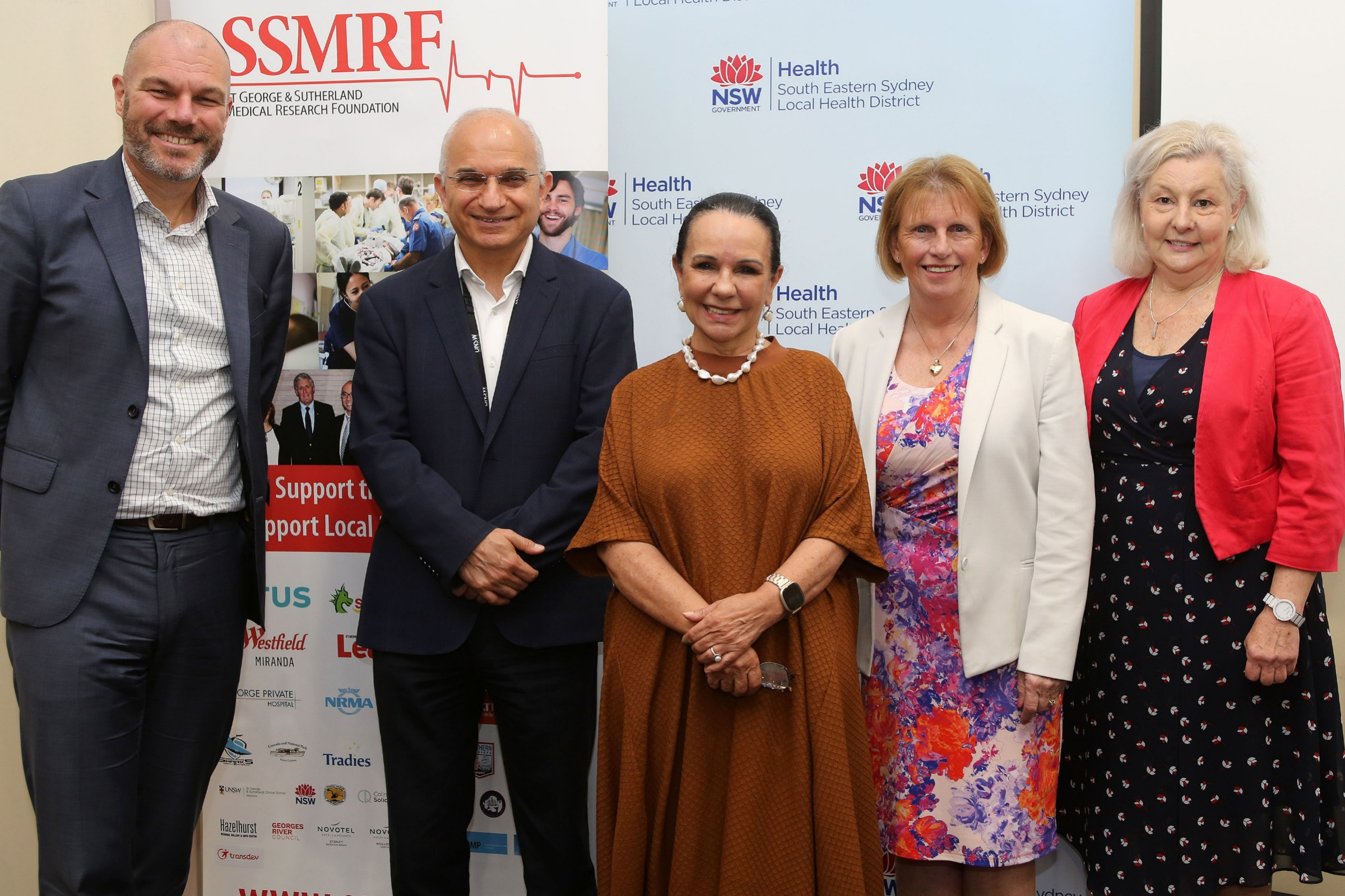 Staff in a row smiling for the camera at the Symposium