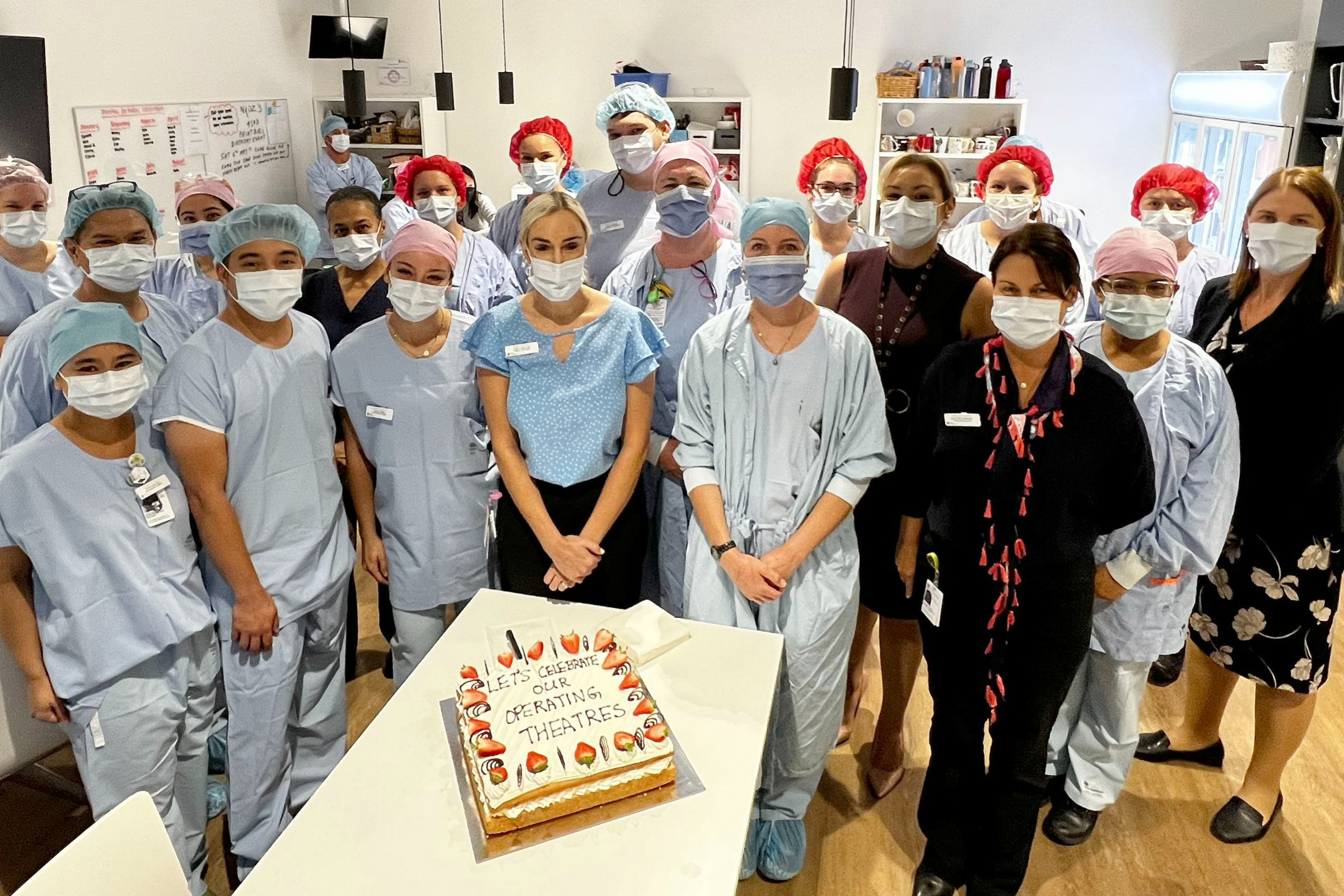 Staff from the operating theaters and post-anaesthetic care unit celebrate the opening of the new area with cake