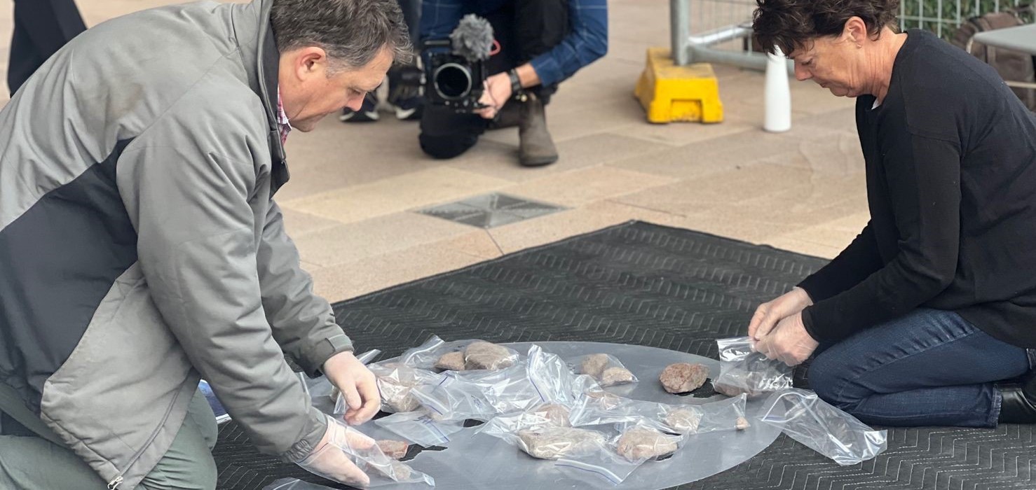 Archaeologists positioning ancient hearth stones