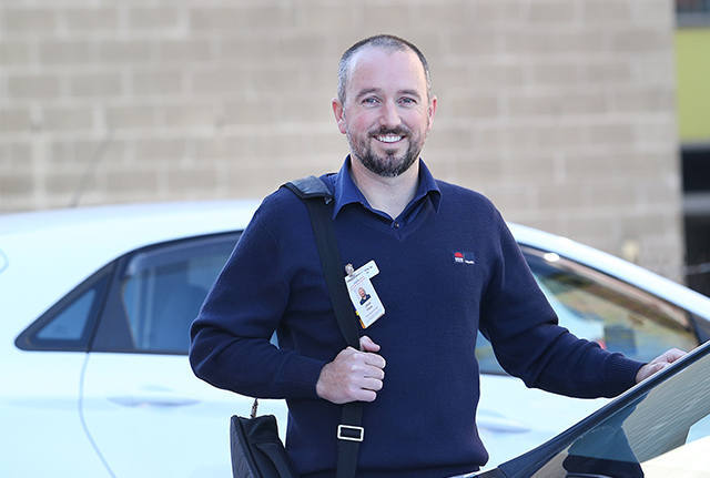Nurse standing next to car