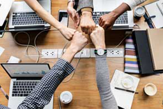 Meeting with hands fist pumping over desk