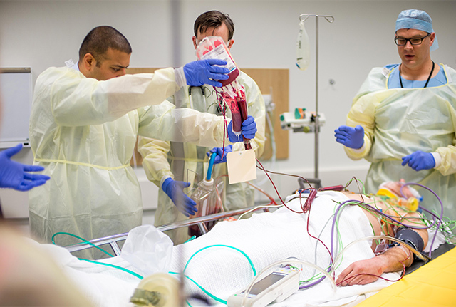 Critical patient with emergency medicine staff attending to them