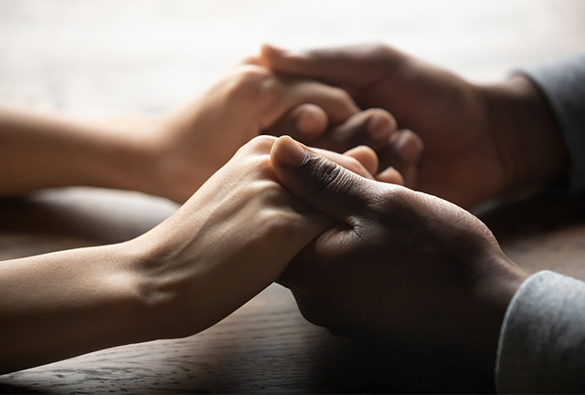 Close up of two hands holding each other