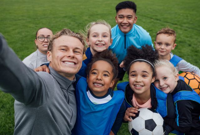 Children and young people posing for a selfie after a soccer match
