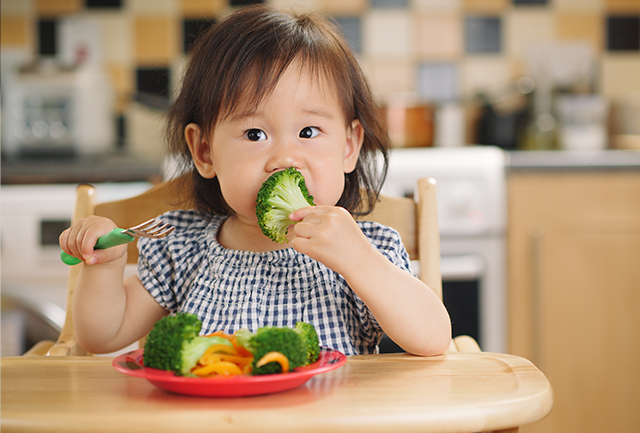 A toddler self-feeding