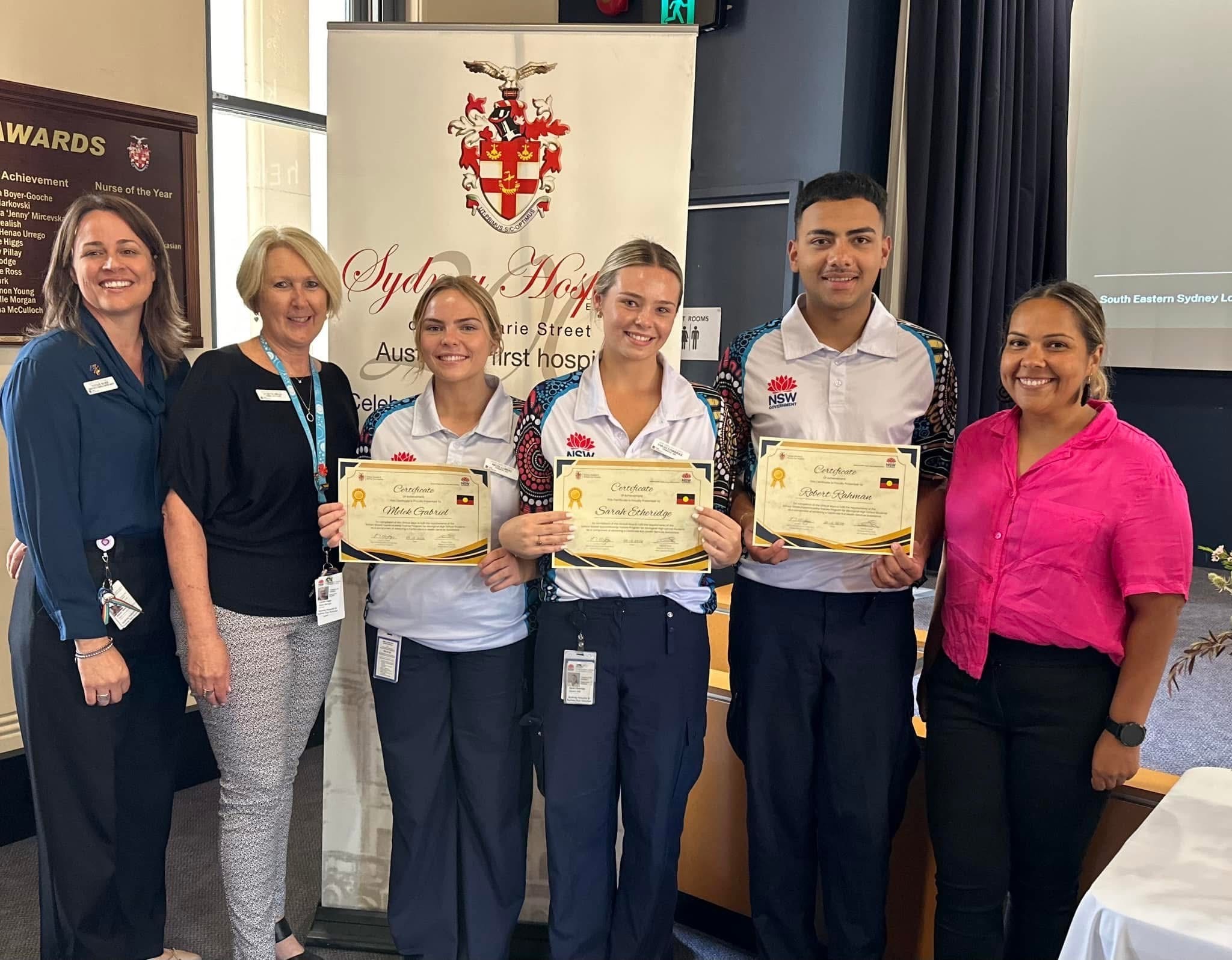 Group of six people holding certificates