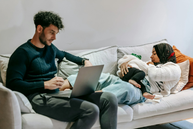 Father on computer, mother holds child