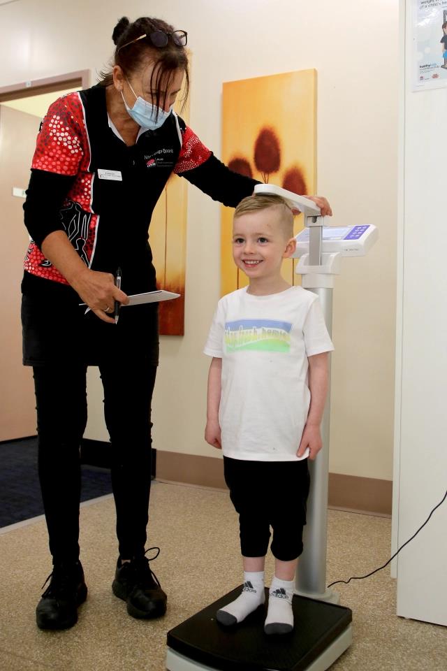 Child on scales with clinician