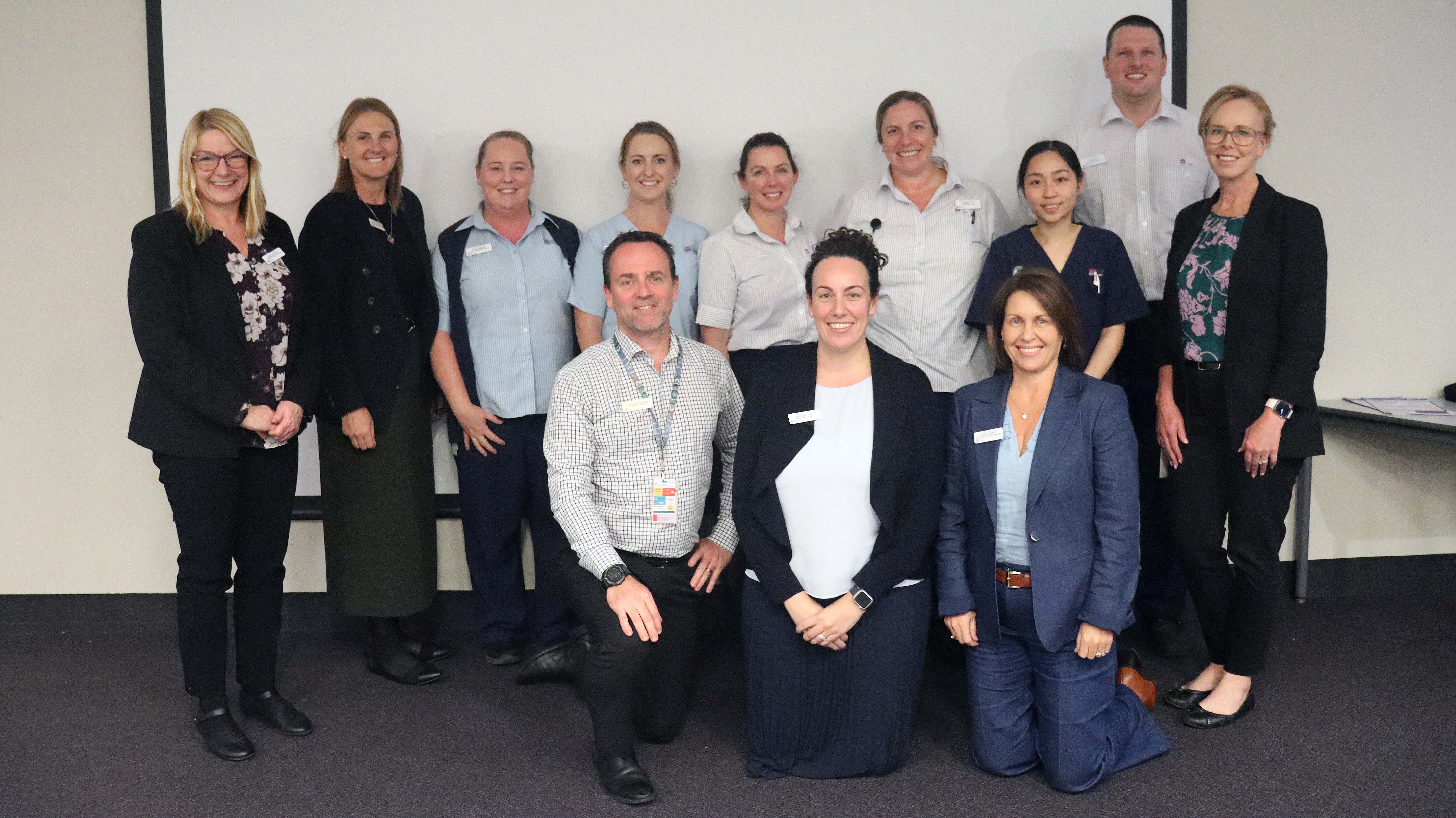 Group of 11 smiling nurses and midwives at forum