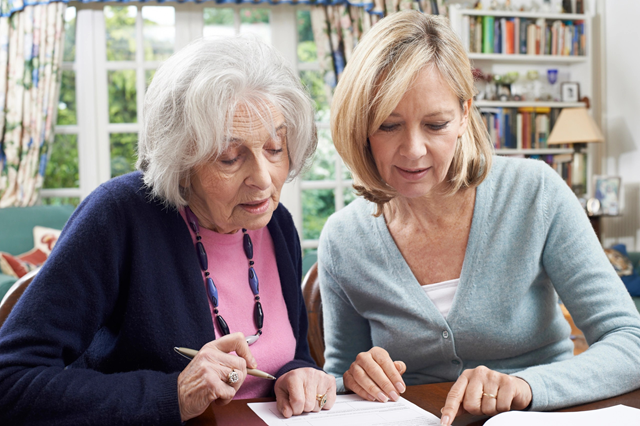 Care coordinator providing health coaching an ederly woman