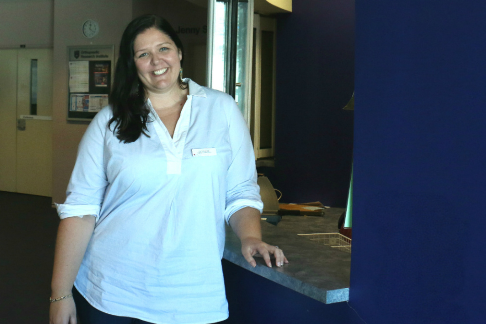 Elizabeth Walter standing next to reception desk