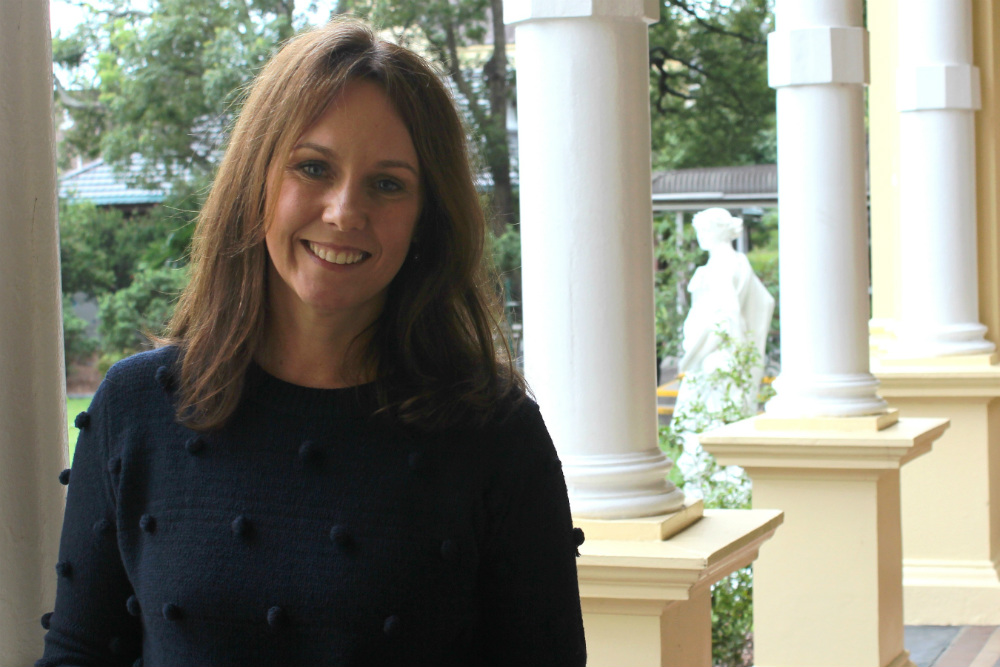 Diane Gellatly standing on veranda of old building