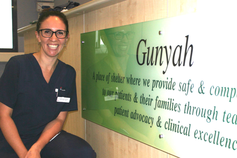 Stephanie Negro kneeling against ward sign