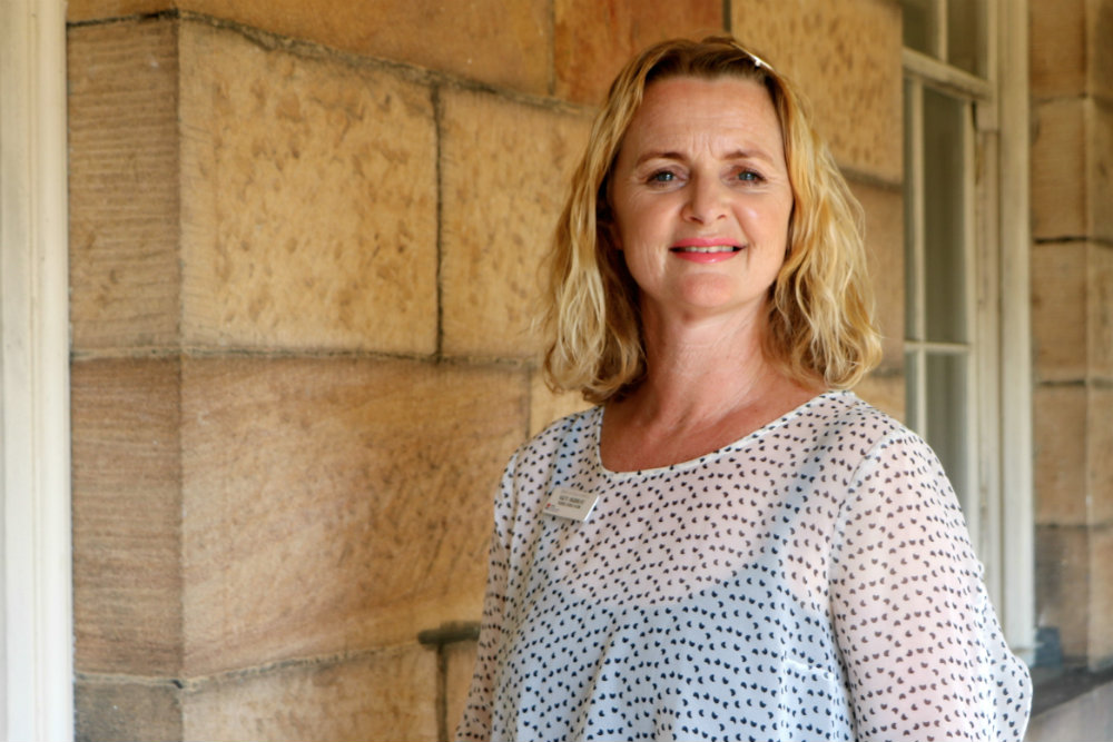 Suzanne Murray standing in front of sandstone wall