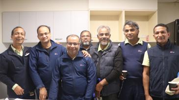 group of environmental support staff standing smiling for a photo