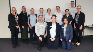 Group of 11 smiling nurses and midwives at forum